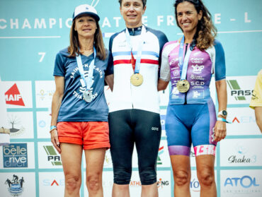 Trois coureuses de triathlon sur un podium. Agnès Legris est au centre, sur la plus haute marche.