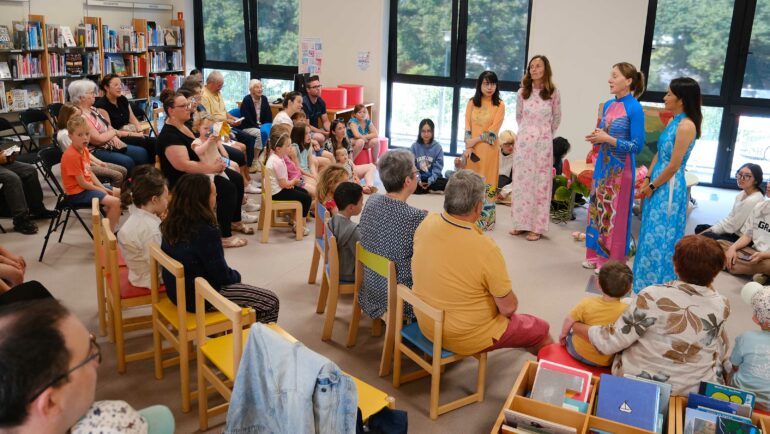 Intervention de bénévoles en tenus traditionnelle vietnamienne dans une salle de classe.